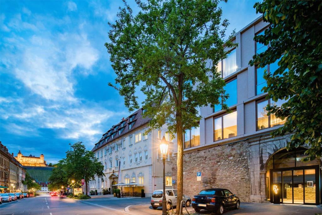 a building on a street with cars parked in front of it at Best Western Premier Hotel Rebstock in Würzburg