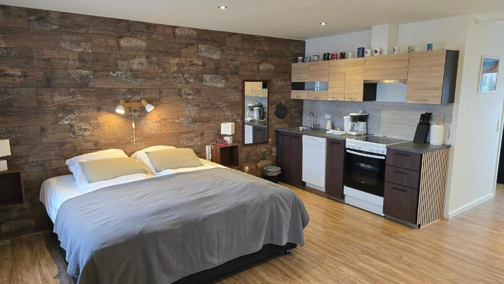 a bedroom with a large bed and a kitchen at Vestbjerg Apartments in Vestbjerg