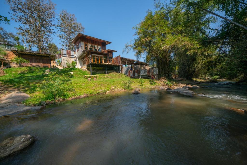 a house on a hill next to a river at Cozy Home Saluang in Ban Lua Ka