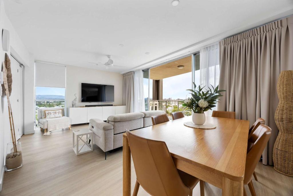 a dining room and living room with a table and chairs at Stylish Beachside Retreat in Gold Coast