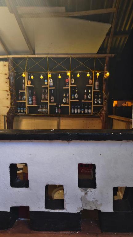 a room with a counter with a shelf with bottles at Newdarling beach hotel in Watamu