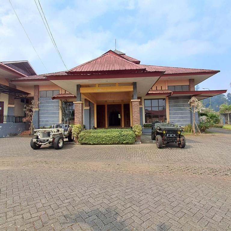 a building with four jeeps parked in front of it at Grand Pujon View in Songgoriti