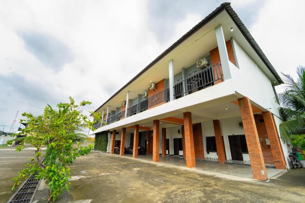 a white building with a balcony on the side at Hotel Tiara By ARBA in Weleri