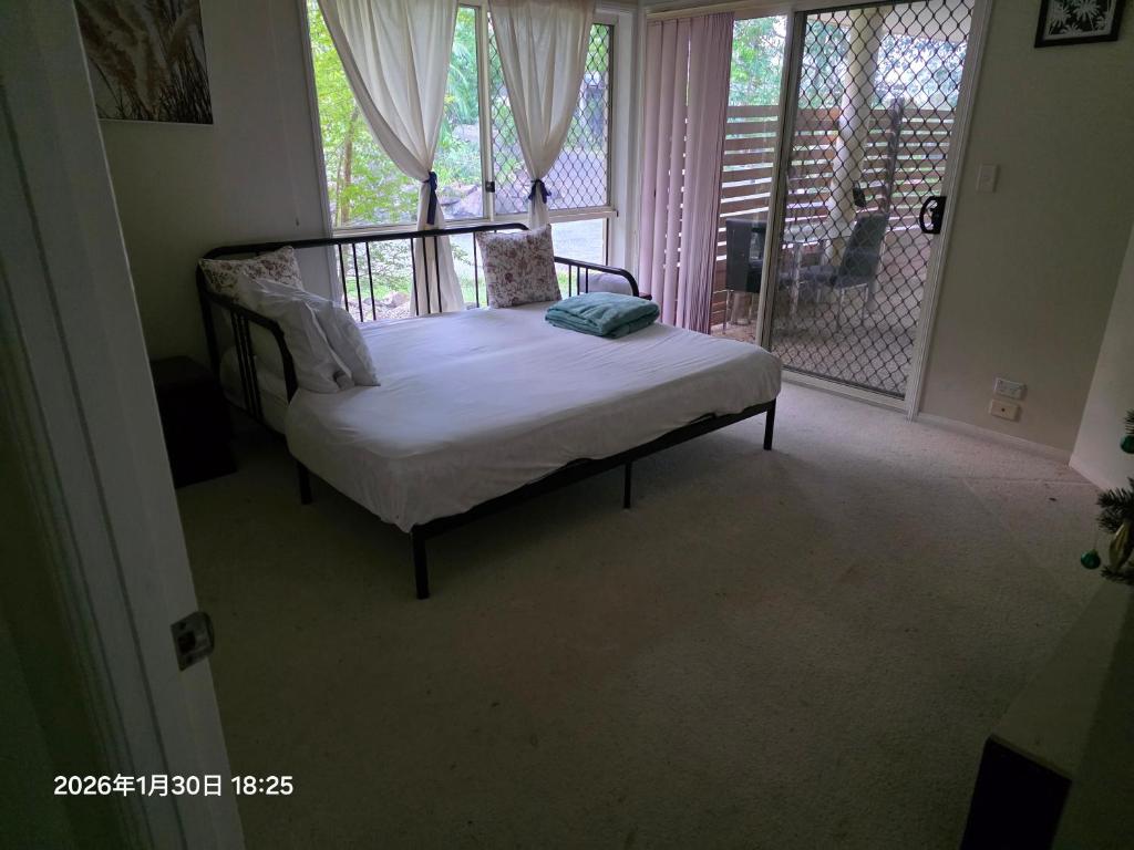 a bed in a room with a window and a porch at Gaven Garden in Gold Coast