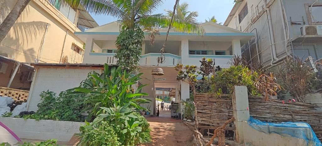 a house with a palm tree in front of it at Yog Inn in Varkala