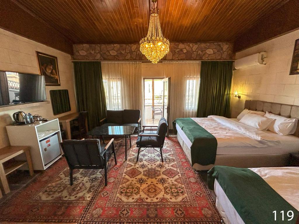 a hotel room with two beds and a table and chairs at ARİFBEY KONAGİ otel in Şahinbey
