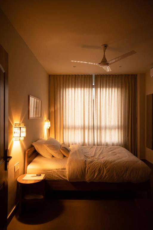 a bedroom with a large bed with a window at Ara Ki Serviced Apartments in Kohīma