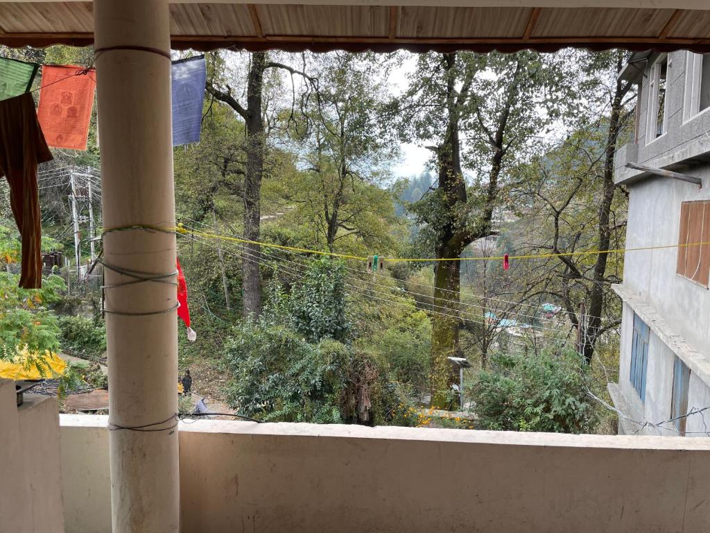 a view of a garden from a balcony with clotheslines at Kingdom Homestays in Manāli
