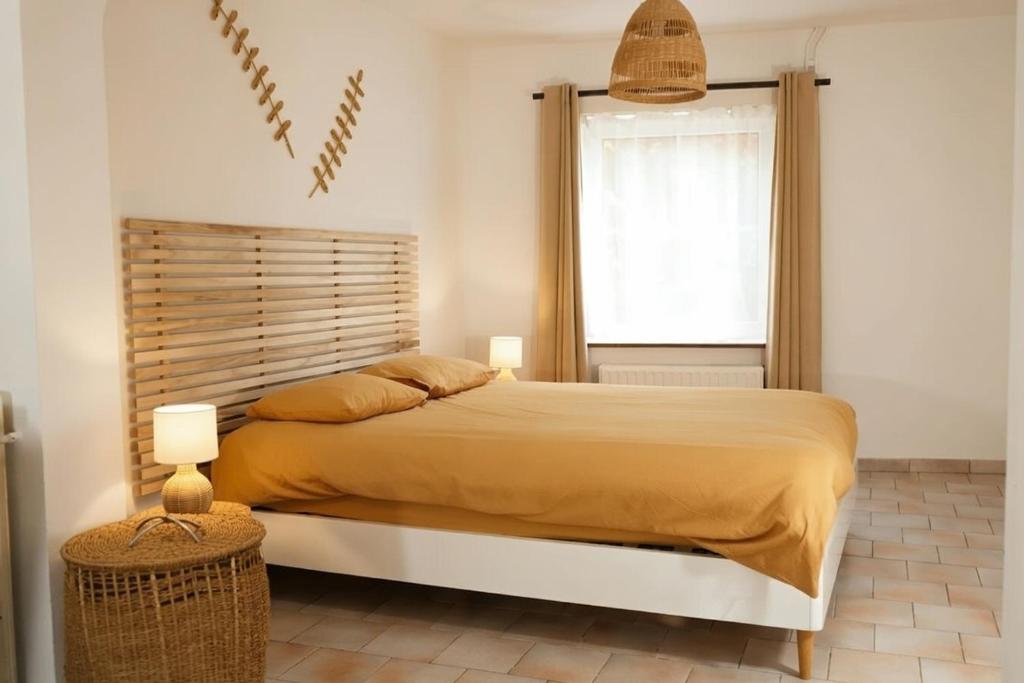 a bedroom with a large bed and a window at La Maisonnette - 2 chambres, parking, jardinet & calme in Tournai