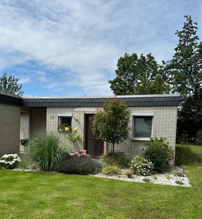 a brick house with a garden in front of it at Ferienhaus Wattglück Tossens in Butjadingen