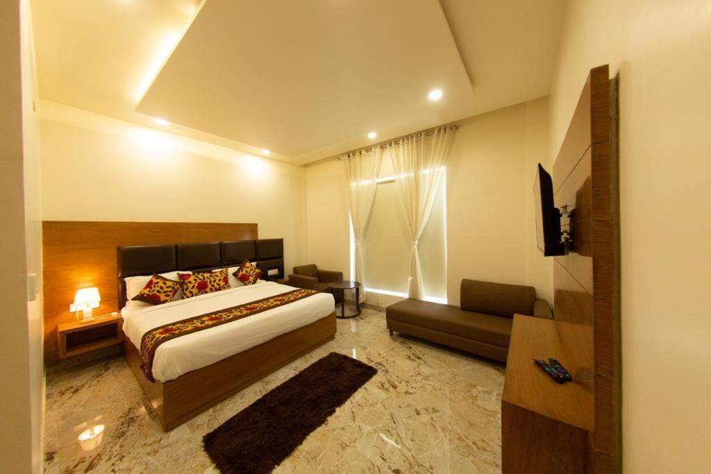 a hotel room with a bed and a couch at Comfort By Choice in Amritsar