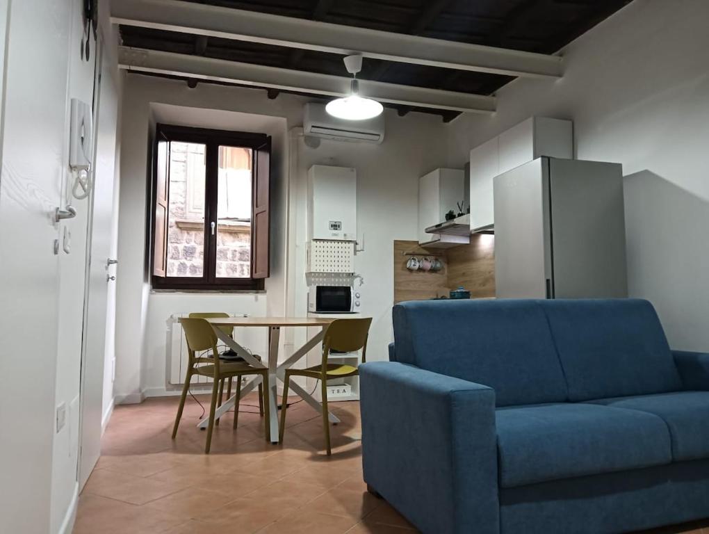 a living room with a blue couch and a table at A Casa di MaPe in Viterbo