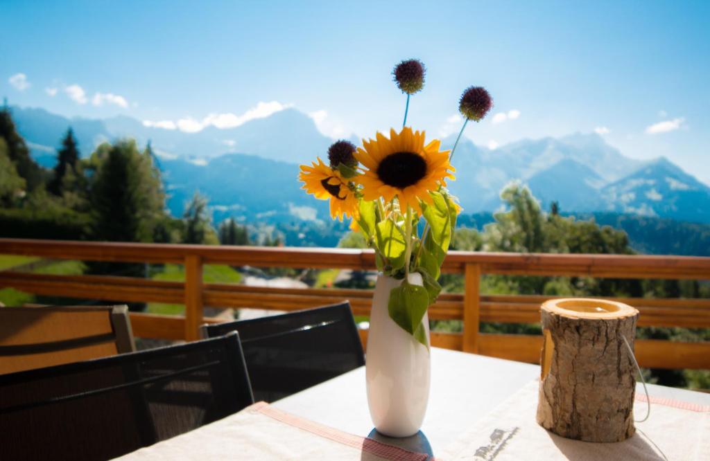 a vase filled with sunflowers sitting on a table at Le Bristol - Villars Bristol Apartments in Villars-sur-Ollon