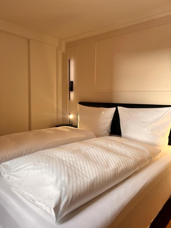 a bedroom with two beds with white sheets at City Apartment 1 in Euskirchen