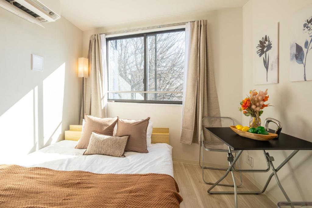 a bedroom with a bed and a desk and a window at Mi-Hotel Nakano- Shinjuku Direct 中野南台 in Tokyo
