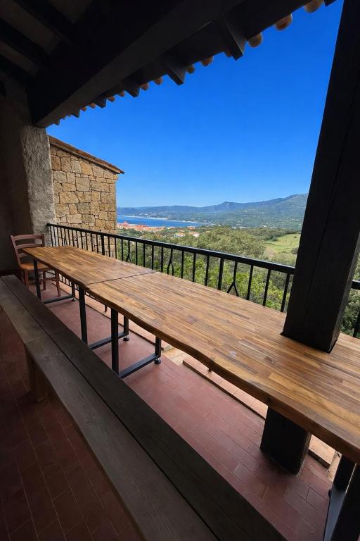a wooden bench sitting on a porch with a view at Maison avec vue mer à Propriano in Propriano