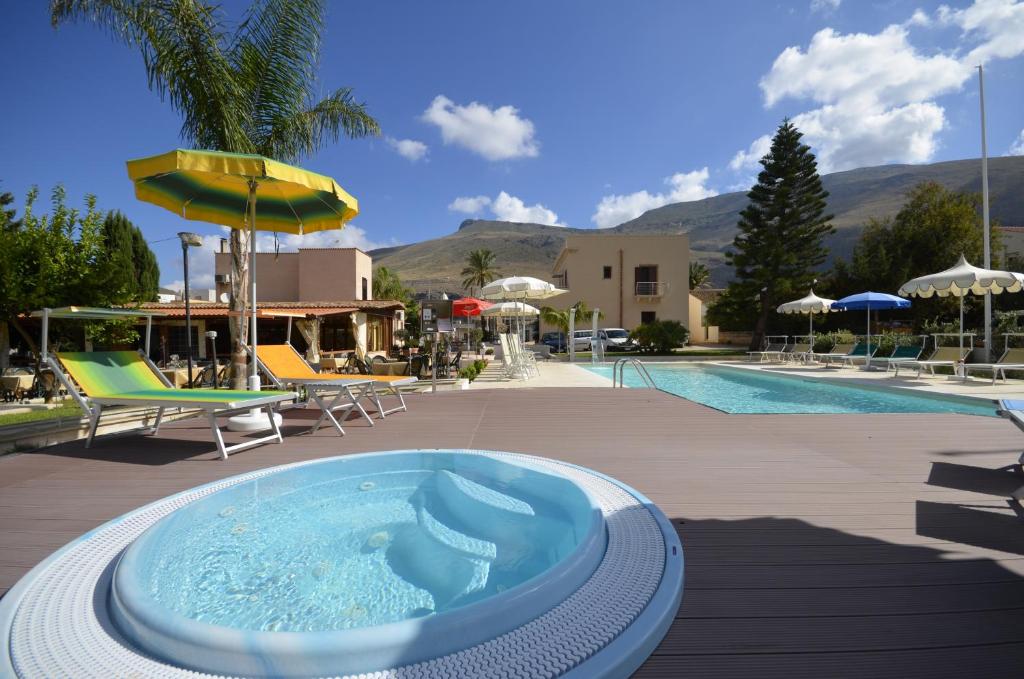 une piscine avec un bain à remous à côté d'un complexe dans l'établissement Hotel Oasi da Paolo, à Castelluzzo