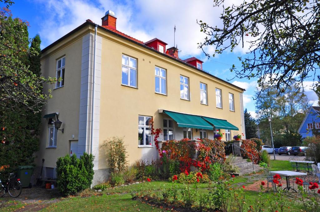 un bâtiment avec un jardin en face dans l'établissement Pensionat Prästgården, à Töreboda