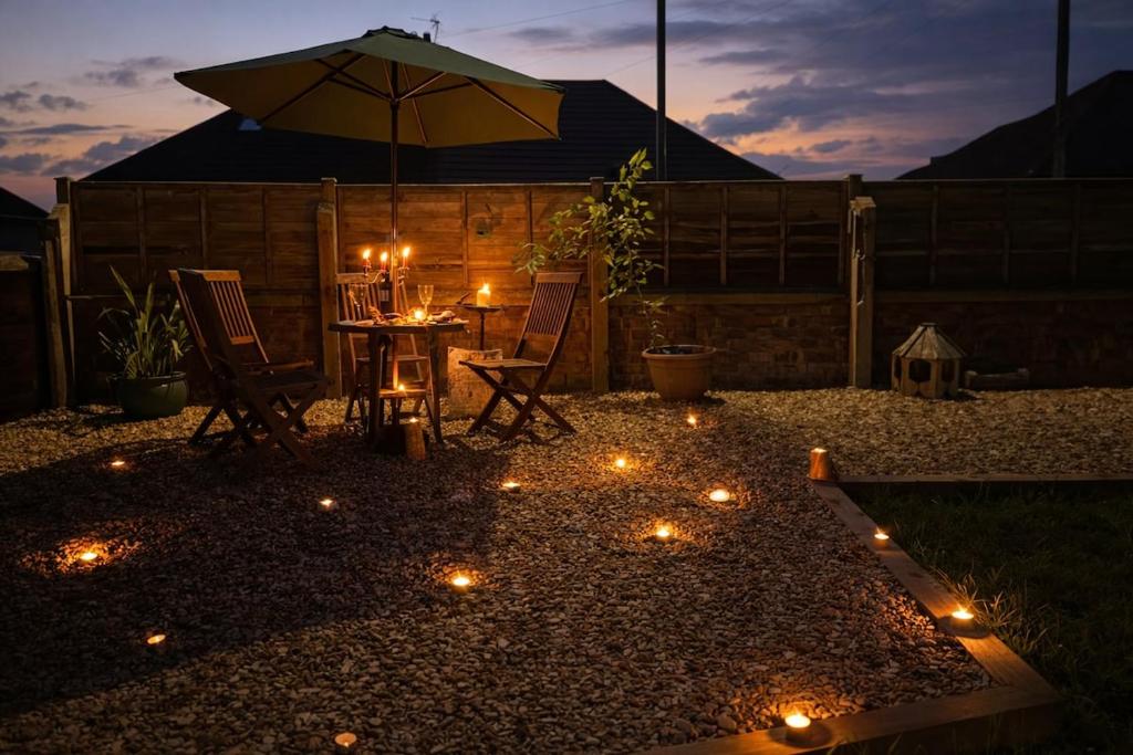 a patio with a table and chairs and an umbrella at 3 Bed Bungalow with Large Garden in Westoe
