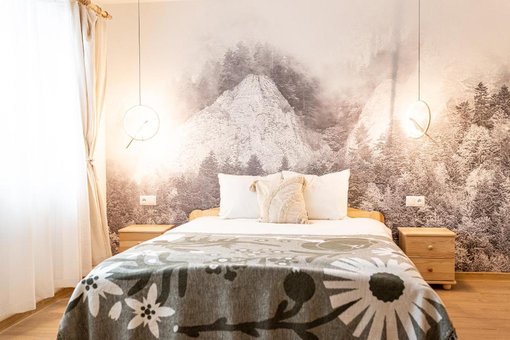 a bedroom with a bed with a large painting on the wall at Markowa Chata in Mizerna