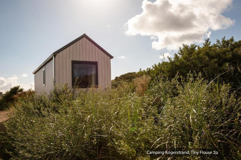 a small house sitting on top of a hill at Texelcampings - Kogerstrand in De Koog