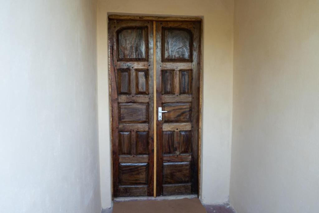 a wooden door in the corner of a room at Rasal homes in Gazi