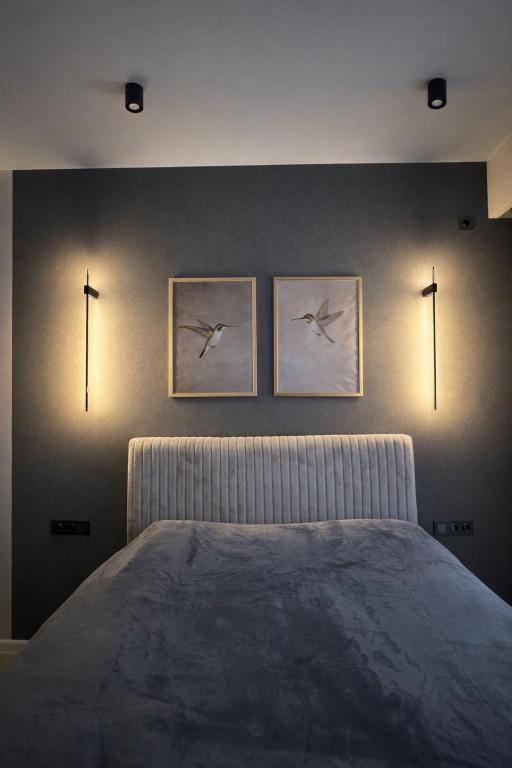 a bedroom with a bed with two birds on the wall at Fatmanis 98 in Tbilisi City