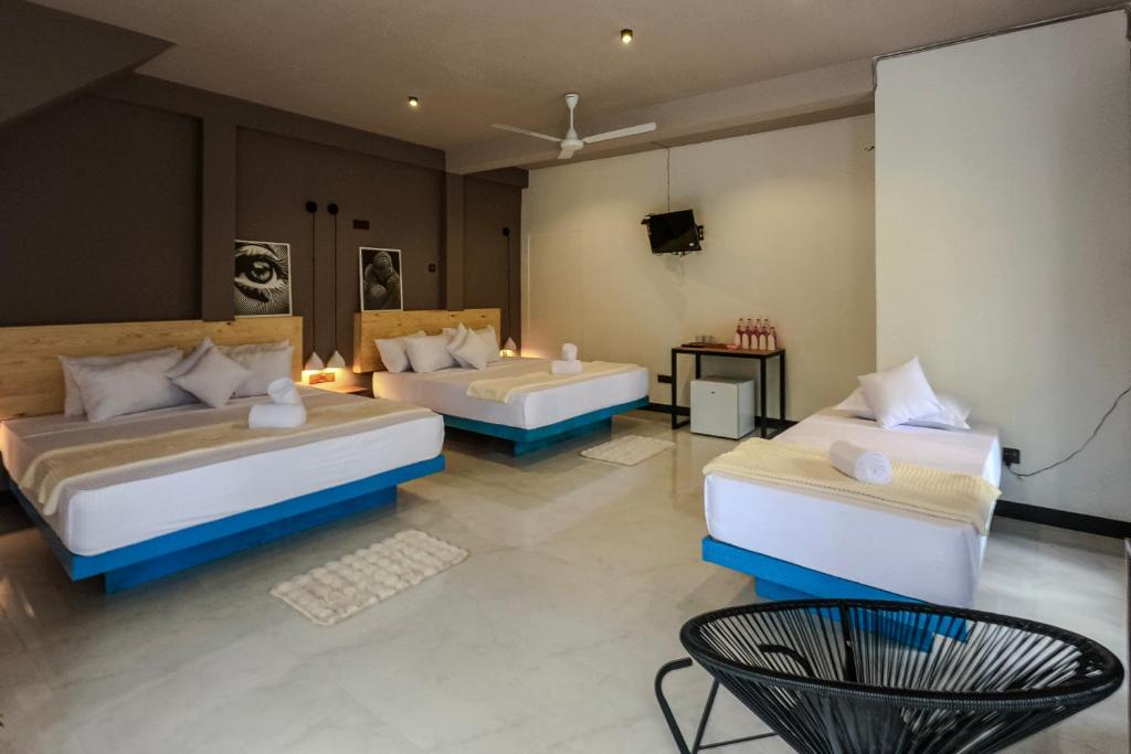 a hotel room with two beds and a television at Ayana Gardens Ella in Ella