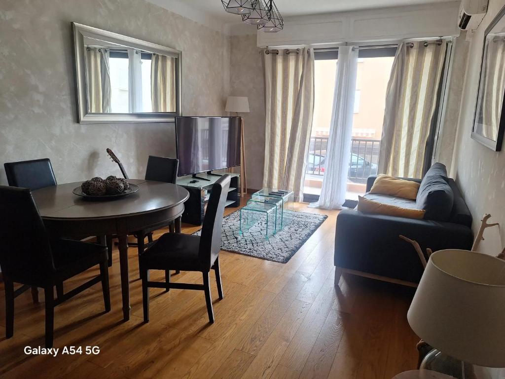 a living room with a table and a couch at Appartement confortable à Propriano avec balcon in Propriano