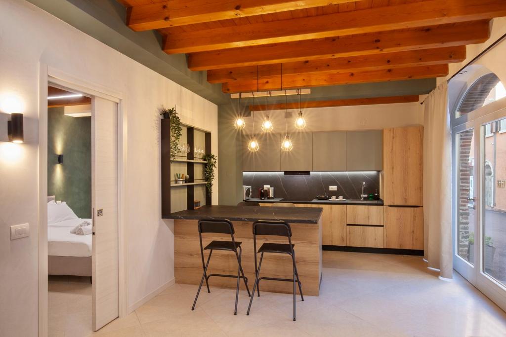 a kitchen with a bar with stools and a bed at Bohemia Apartment in Calmasino