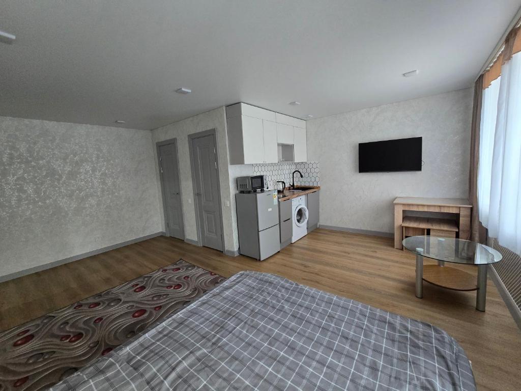 an empty room with a kitchen and a living room at Возле Нарыка in Ekibastuz