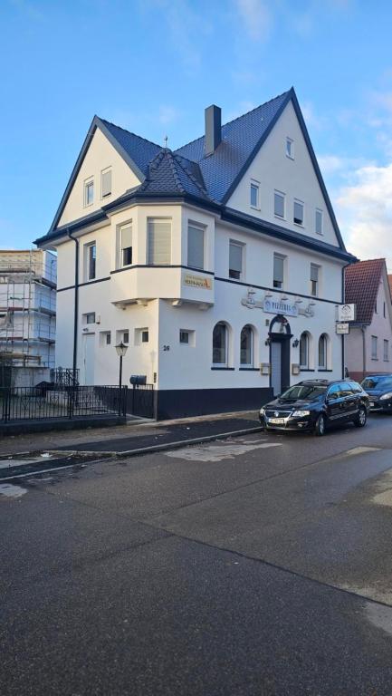 a large white building with cars parked in front of it at Zum Hexenhäusle in Kornwestheim