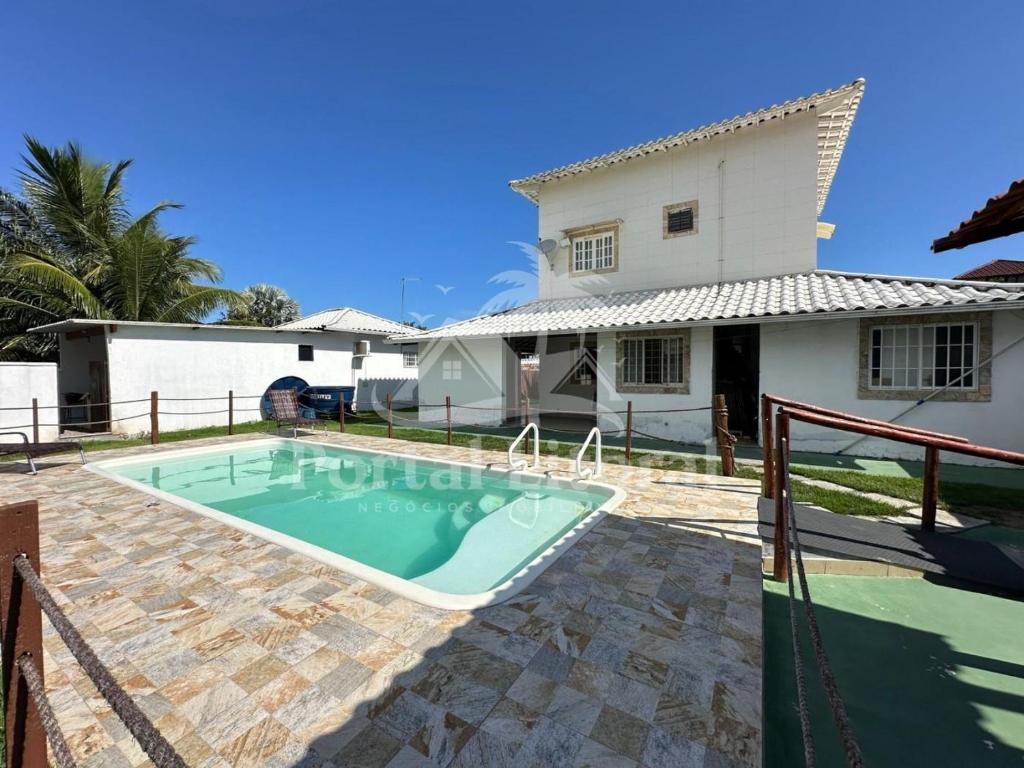 a swimming pool in front of a house at Casa Branca in Saquarema