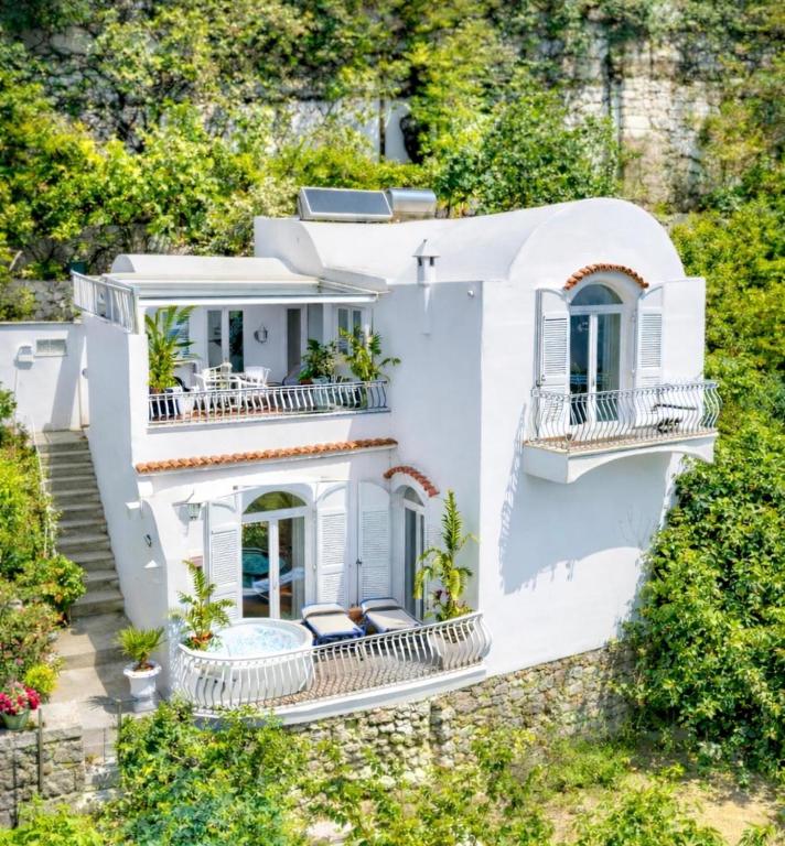 a white house with balconies and trees at Villa Navarra in Praiano