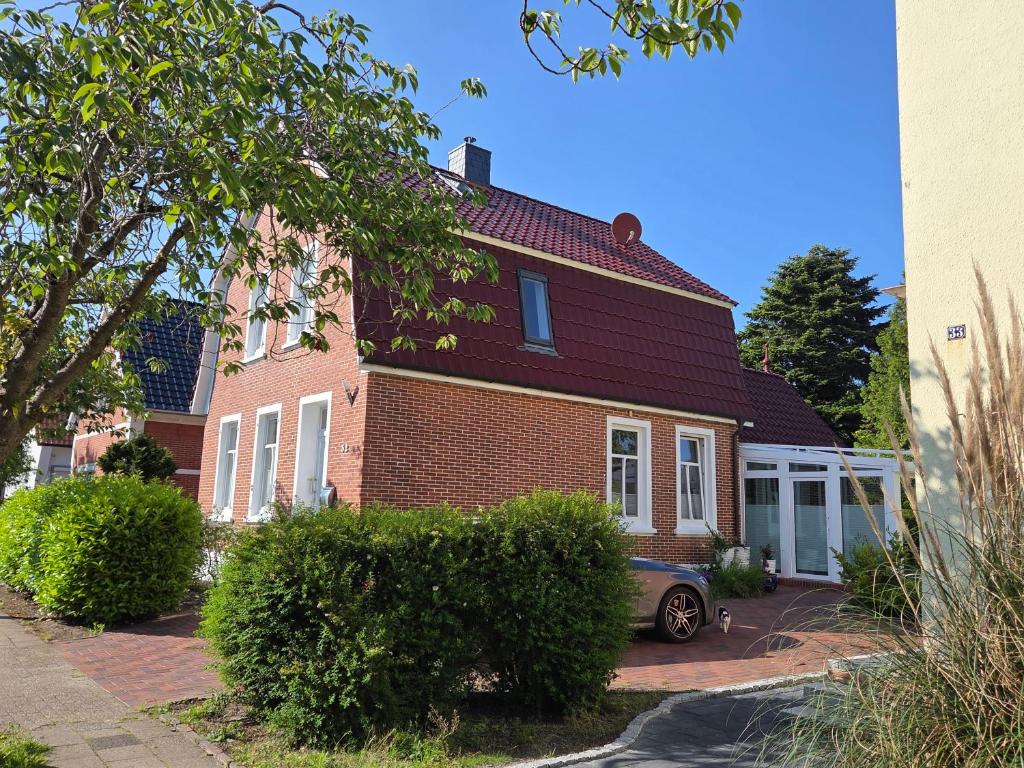 a brick house with a car parked in front of it at Stadtvilla Norden in Norden