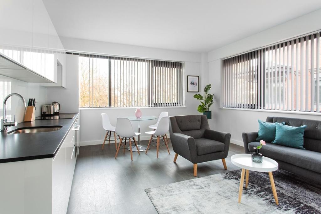 a living room with a couch and a table at Abbott House by Viridian Apartments in St. Albans