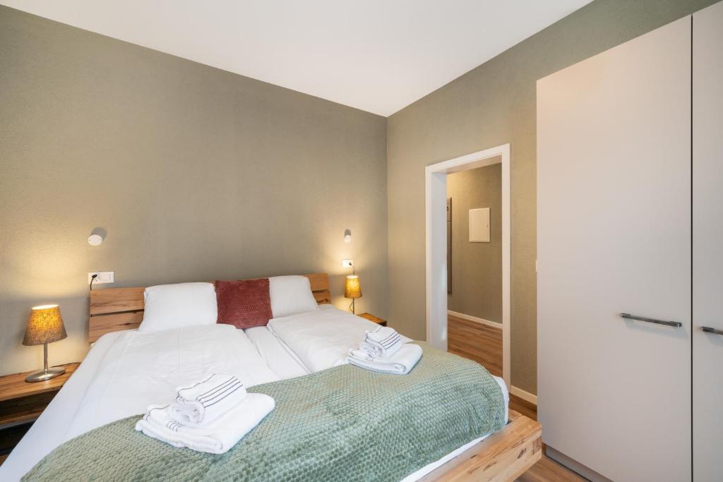 a bedroom with a bed with two towels on it at BetweenLakes Apartment ground fl in Interlaken