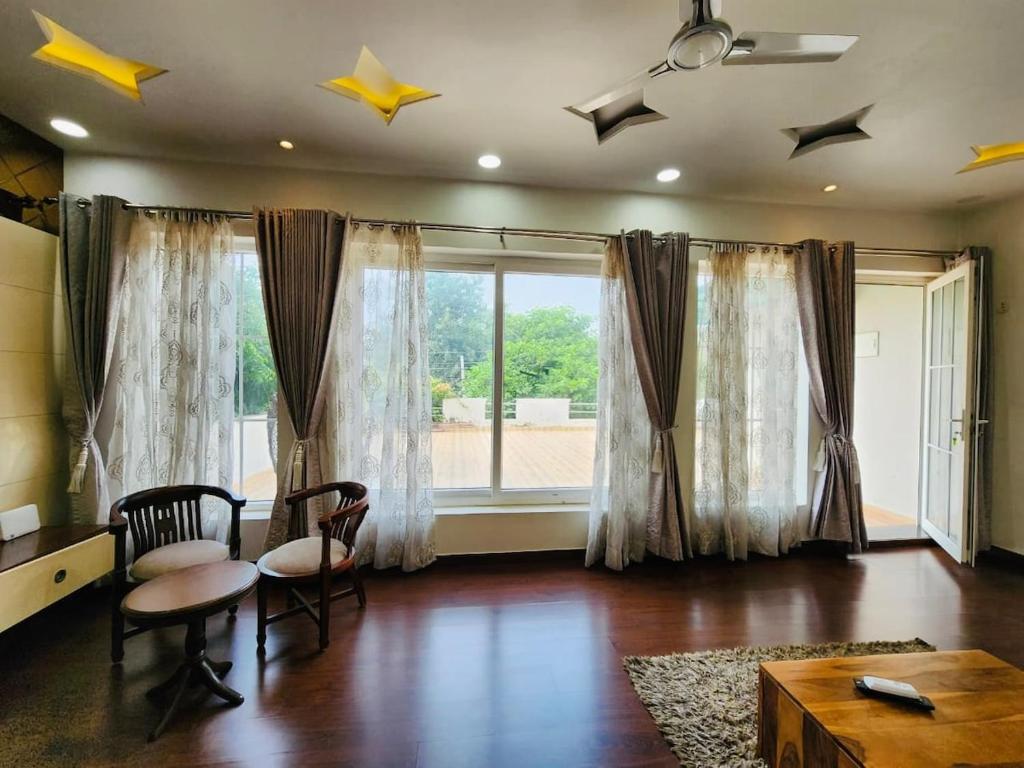 a living room with a table and chairs and a window at The leaf and Hill in Alwar