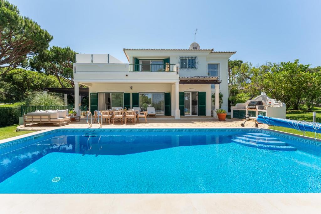 a villa with a swimming pool in front of a house at Villa Mia - Vale do Lobo in Vale do Lobo