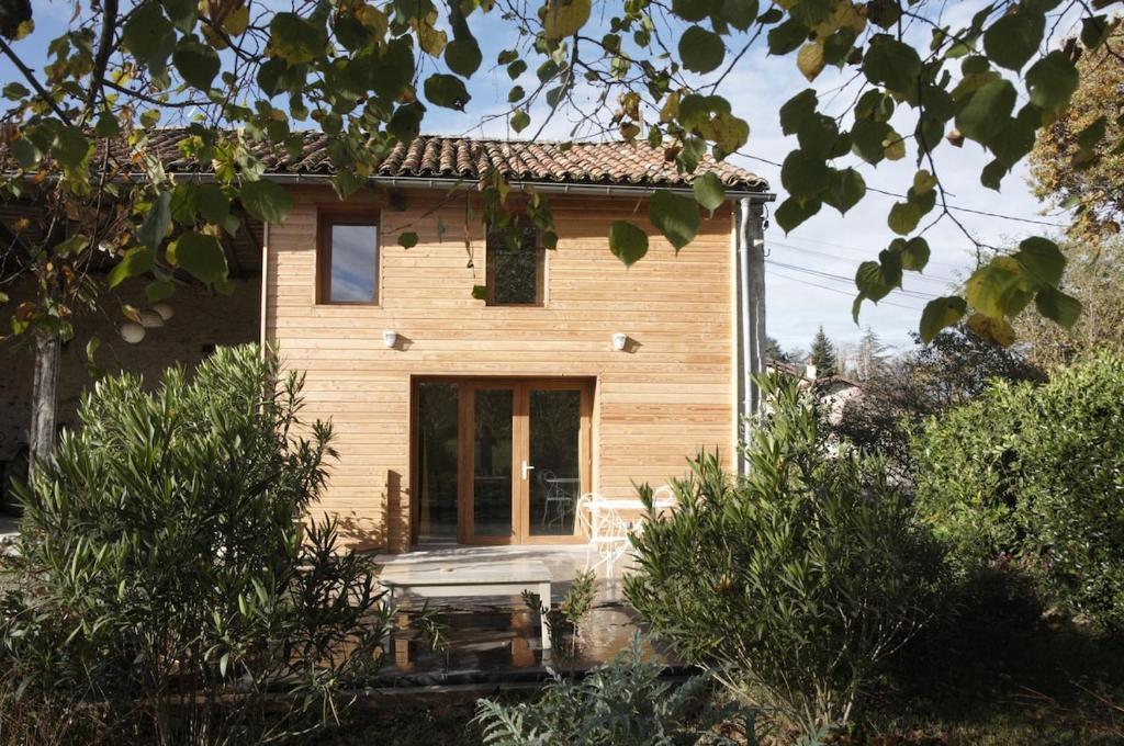 a small wooden house with a large glass door at Appartement LE CHAI in Saint-Gaudens