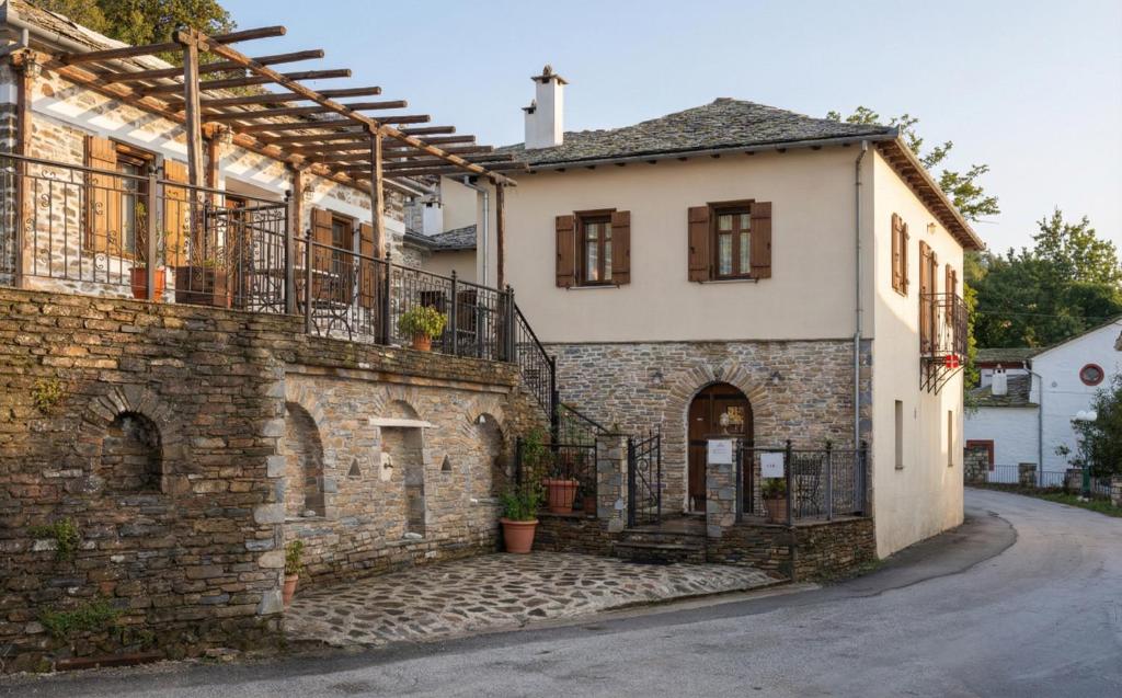 a stone house with a balcony and a street at Archontiko Papoutsi Pelion in Mouresi