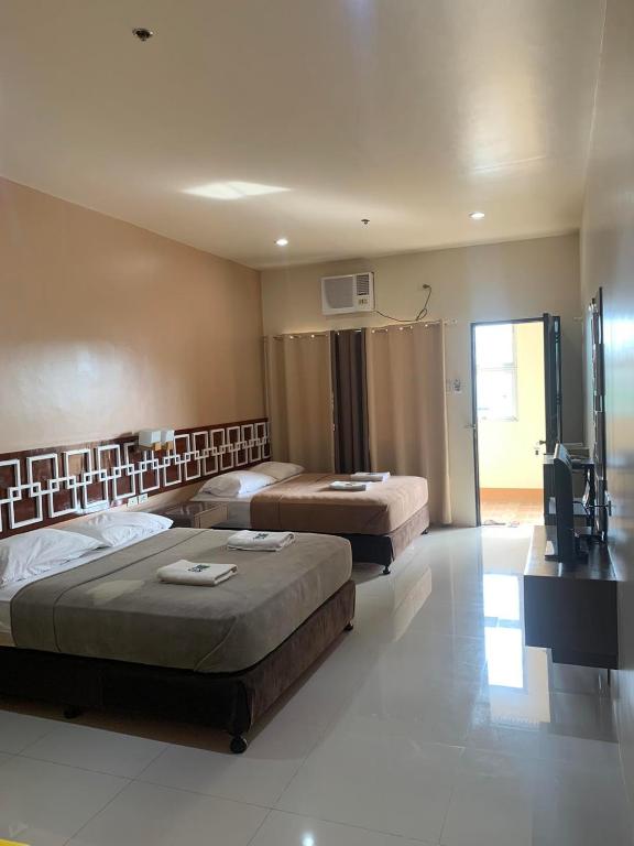 a hotel room with two beds and a television at Zion Pension House in Ozamis