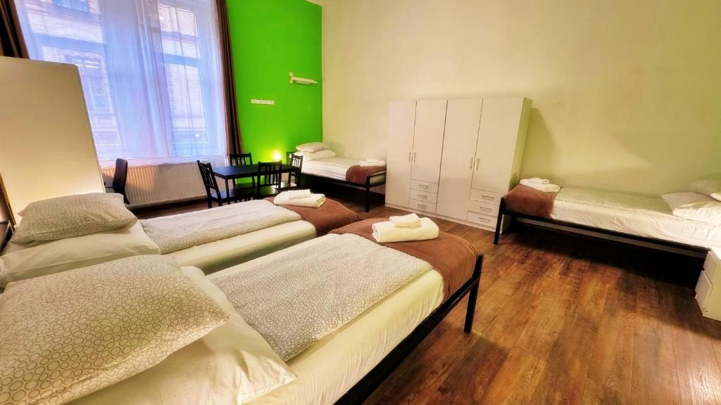 a room with four beds and a green wall at BeBudgetRooms in Budapest