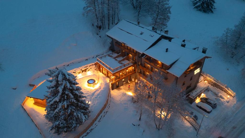 an aerial view of a house with lights in the snow at Albergo Sporting in Peio Fonti