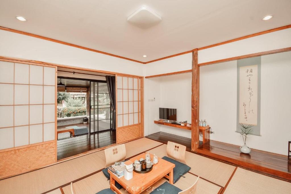 a living room with a table and chairs at Chiangrai Ryokan in Ban Long Khi Na