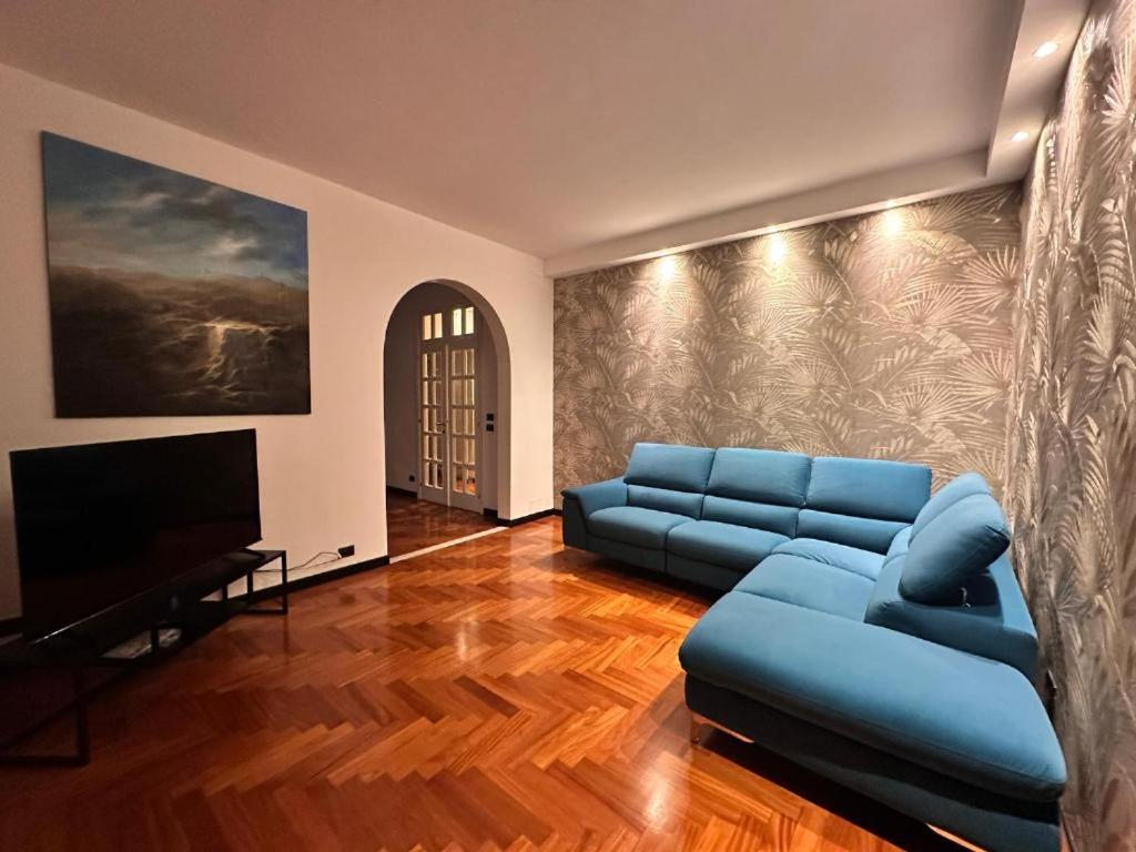 a living room with a blue couch and a television at Appartamento Rosa in Gualdo Tadino