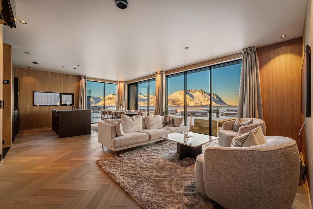 a living room with couches and a large window at New designer cabin in Lofoten in Storøya