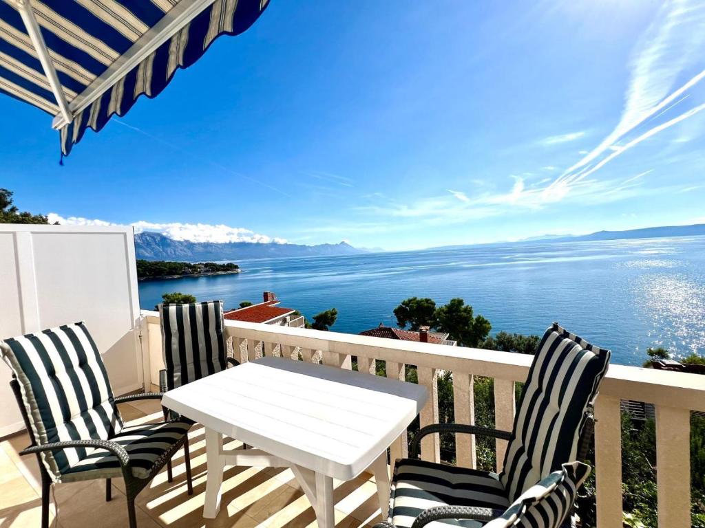 a white table and chairs on a balcony overlooking the water at Villa Sarah in Selca