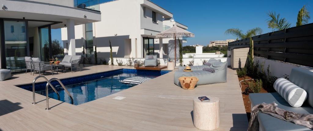a backyard with a swimming pool and a house at Nesea Seaside Luxury Escape in Protaras