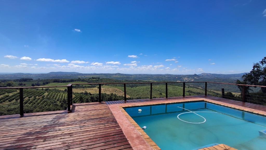a swimming pool on a deck with a view of the mountains at Stille Uitsig Hazyview in Hazyview